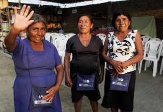 Mujeres damnificadas por las lluvias luego de recibir el kit de protección